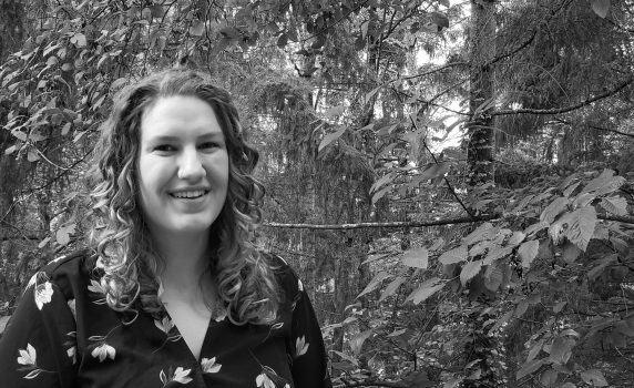 Claire Phillips smiling outside near greenery